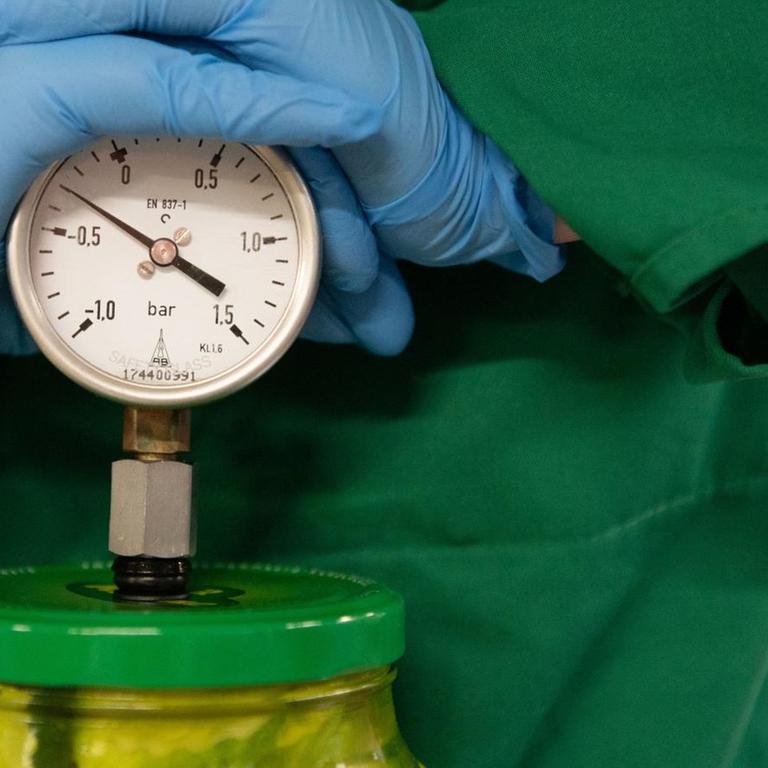 Eine Auszubildende zur Lebensmitteltechnikerin überprüft am 30.07.2019 in einem Gruken-Werk in Schweinfurt das Vakuum innerhalb der Gläser mit Gewürzgurcken 