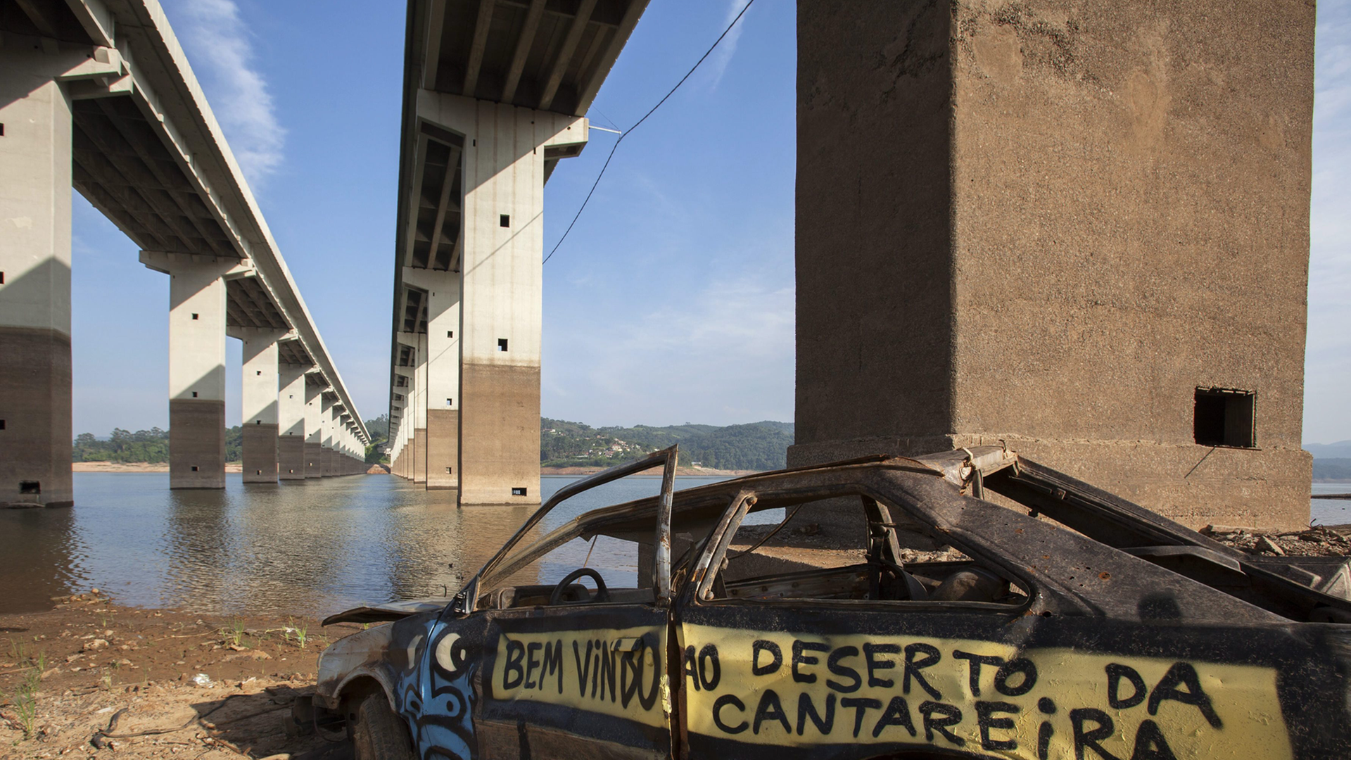 Brückenpfeiler und ein altes Autowrack sind an einem Fluss in Sao Paulo Brasilien zu sehen. Es herrscht eine große Dürre in Brasilien