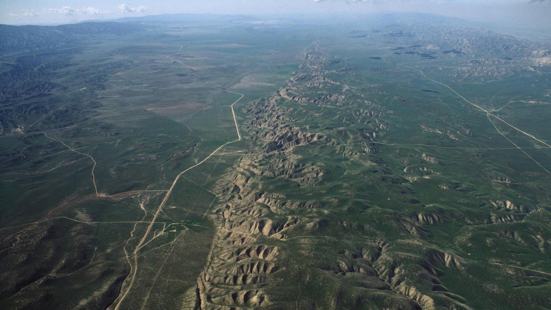 Luftaufnahme der Carrizo-Ebene in Kalifornien. In der Mitte ist deutlich zu erkennen, wie die Gesteinsschichten entlang einer geraden Linie verzerrt werden: Die San Andreas Verwerfung.
