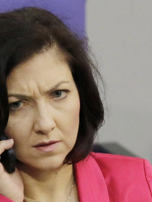 Katherina Reiche im Bundestag mit Handy in der Hand.