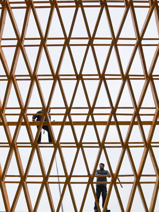Zwei Mitarbeiter der Firma Elite Holzbau an der Dachkonstruktion einer Werkhalle