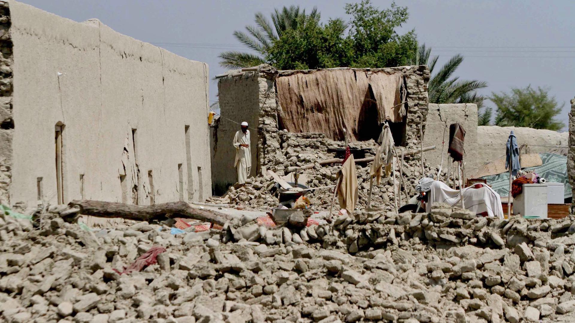 epa03884560 People affected from 7.7 magnitude earthquake wait for relief in Awaran, Balochistan province, Pakistan, 26 September 2013. The death toll from a powerful 7.7 magnitude earthquake that struck south-western Pakistan on 24 September climbed to a