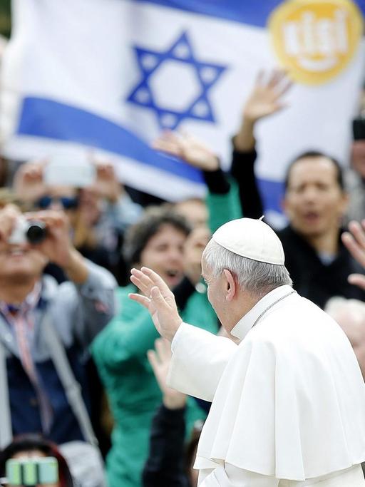 Papst Franziskus in Rom bei einer Audienz, im Hintergrund eine Flagge Israels.
