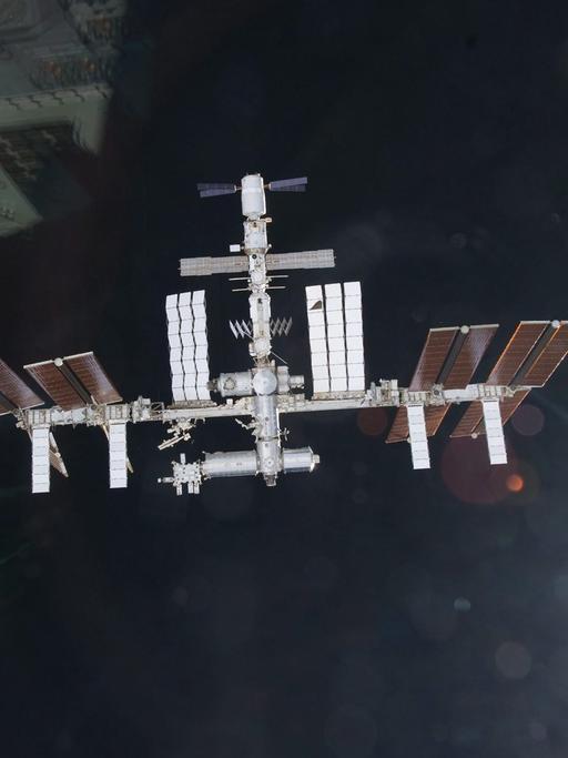 Internationale Raumstation ISS fliegt im Weltall. Im Hintergrund die Erdkugel