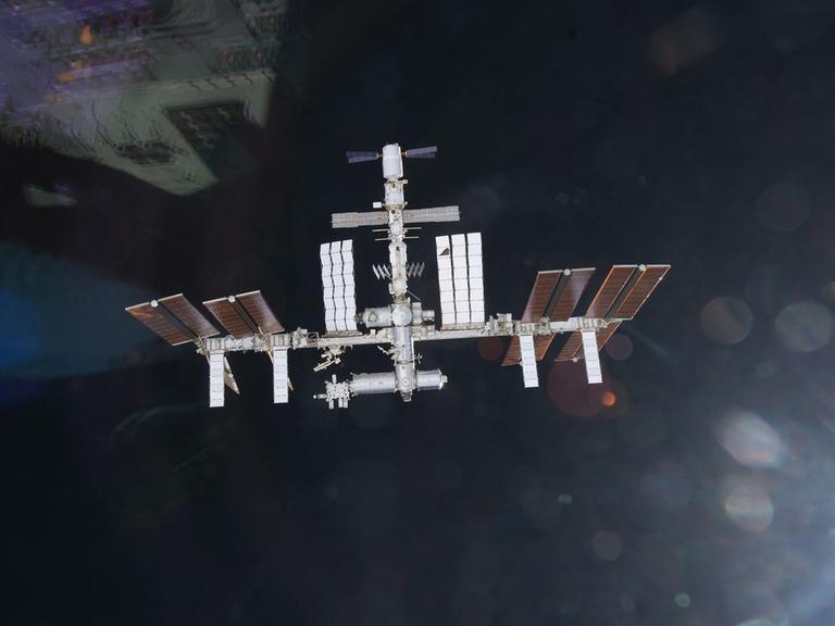 Internationale Raumstation ISS fliegt im Weltall. Im Hintergrund die Erdkugel