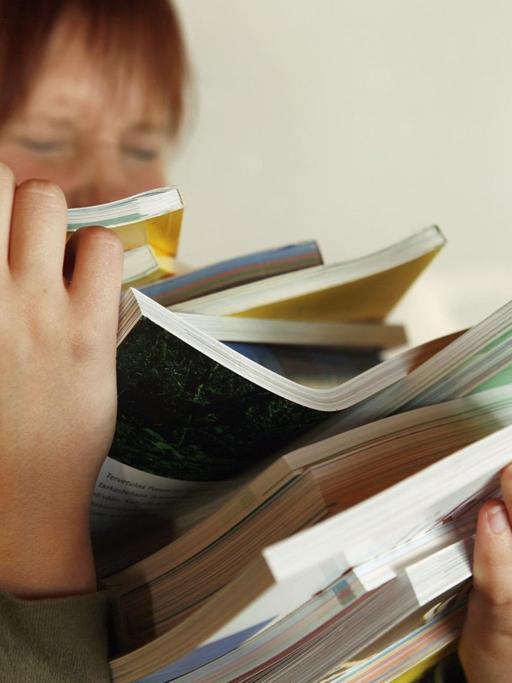 Eine Studentin mit einem Stapel Bücher.