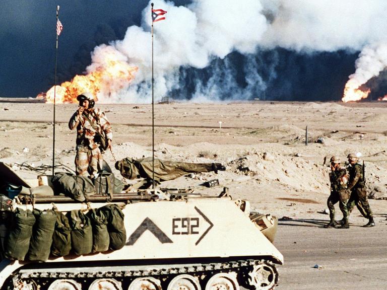 Ein amerikanischer Schützenpanzer vor brennenden Ölfeldern nahe der kuwaitisch-irakischen Grenze am 2.3.1991.