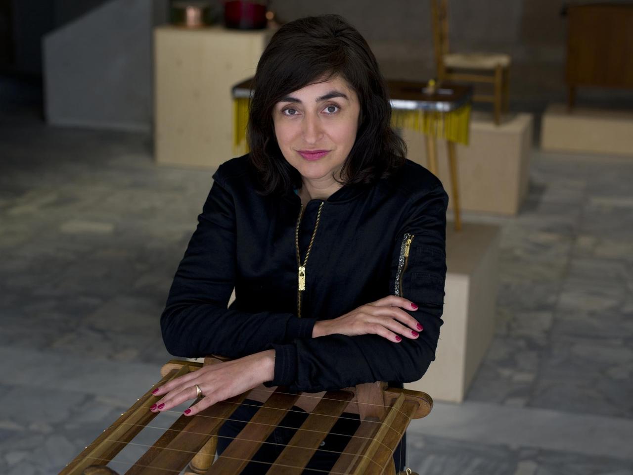 Nevin Aladağ stützt sich auf eines ihrer zum Musikinstrument umgebauten Möbelstücke.