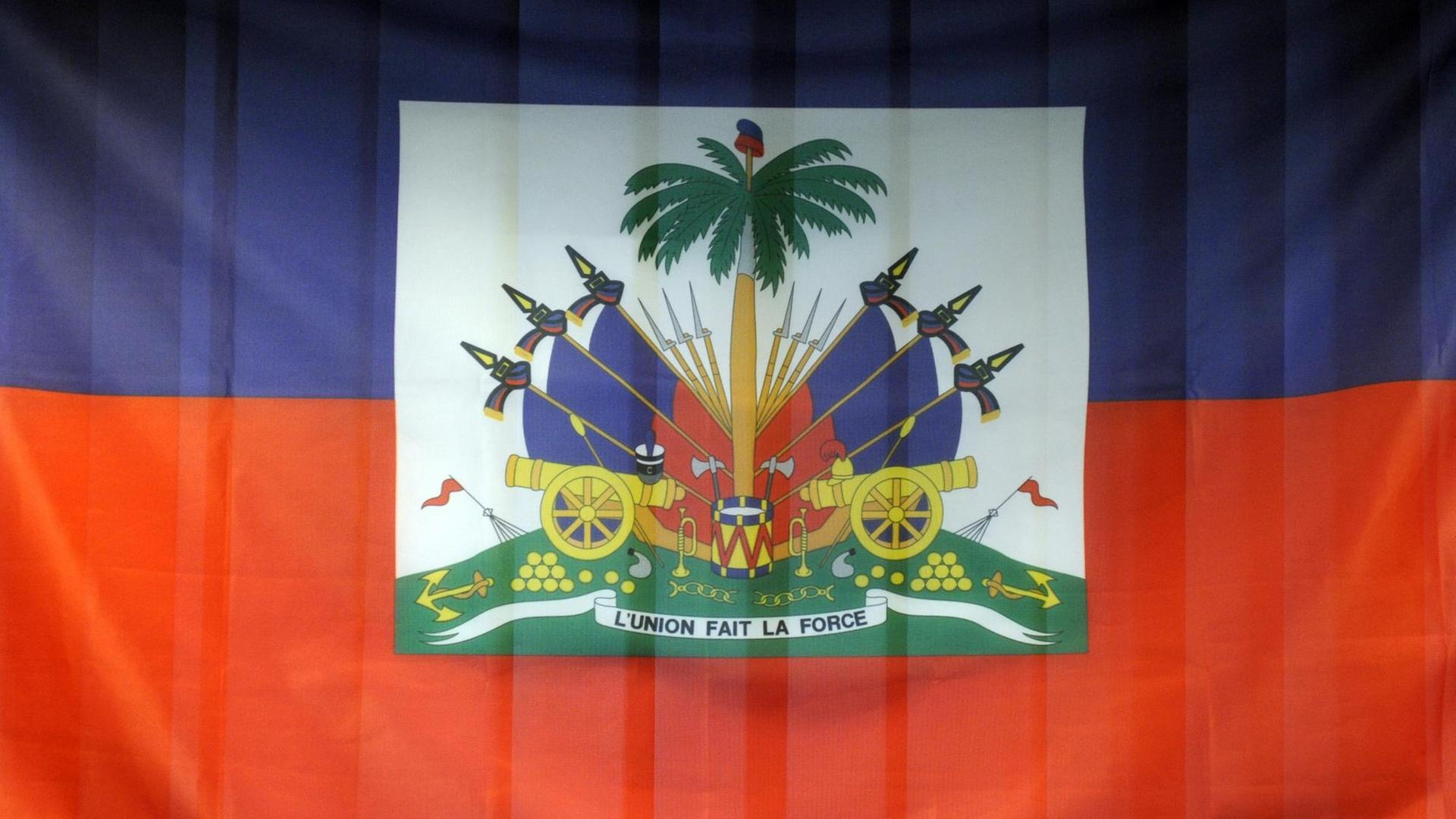 Die Nationalflagge von Haiti besteht aus zwei gleich großen, horizontalen Streifen: oben blau und unten rot. In der Mitte ist das Wappen Haitis abgebildet.