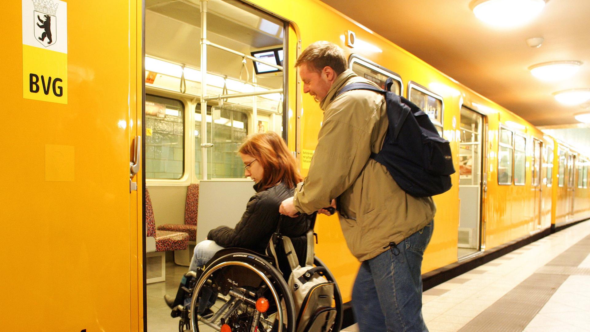 Die Rollstuhlfahrerin Nora Zinke lässt sich von ihrem Freund Martin Manis in Berlin in eine U-Bahn schieben.