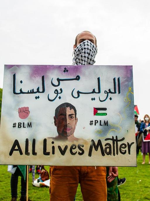 Ein Demonstrant hält ein Schild mit der Aufschrift: "#BLM #PLM All Lives Matter". Ein Demonstrant hält ein Schild mit der Aufschrift: "#BLM #PLM All Lives Matter".