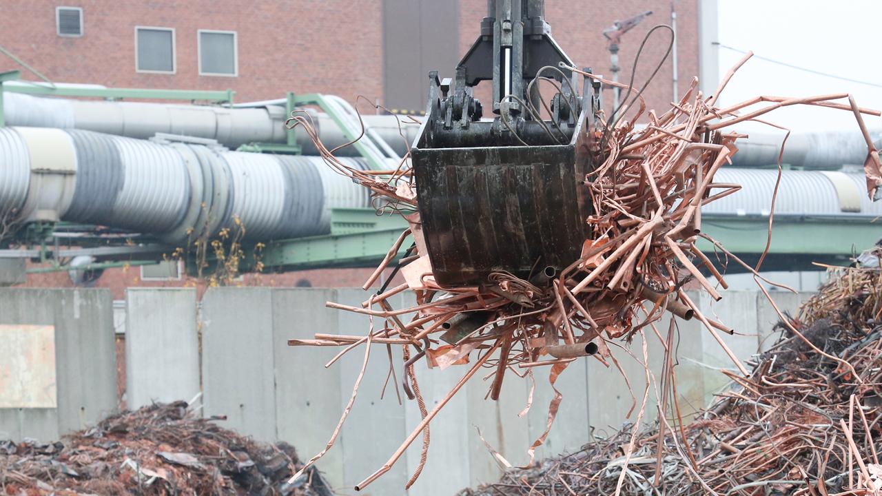 Kupferschrott wird am 04.12.2013 auf einem Hof des Kupferkonzerns Aurubis in Hamburg vor dem Recycling umgeschichtet.