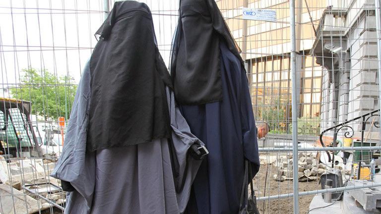 epa02869699 Two women wear burqas while waiting in front of the Saint-Josse / Sint-Joost-ten-Node town hall in Brussels, Belgium, 17 August 2011, where French presidential candidate Rachid Nekkaz (not pictured) arrived to pay the burqa fine of two young women. After Belgium approved an 'anti burqa' law, Nekkaz announced that he would pay any fine for women who want to wear the burqa in Belgium. EPA/JULIEN WARNAND BELGIUM OUT |