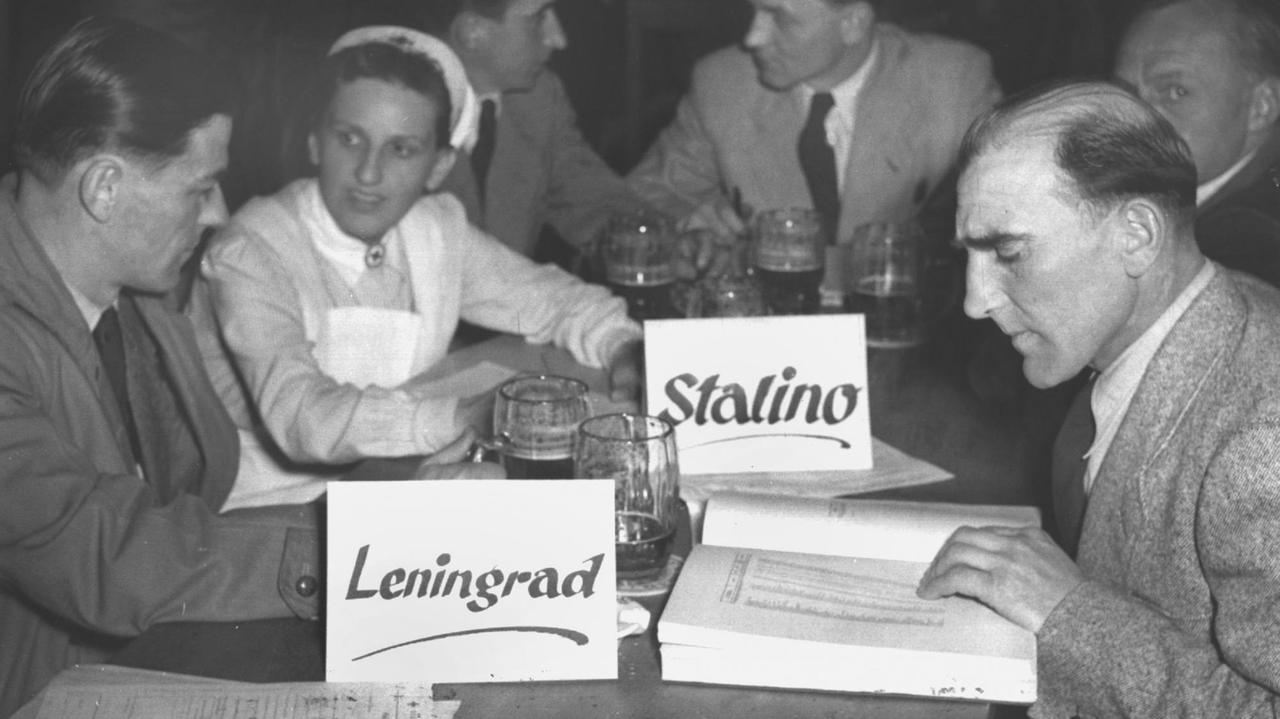 Kriegsgefangene aus den Lagern Stalino und Leningrad geben einer Rotkreuz-Schwester im Münchner Löwenbräu am 1953 Hinweise zu den Namen Verschollener.