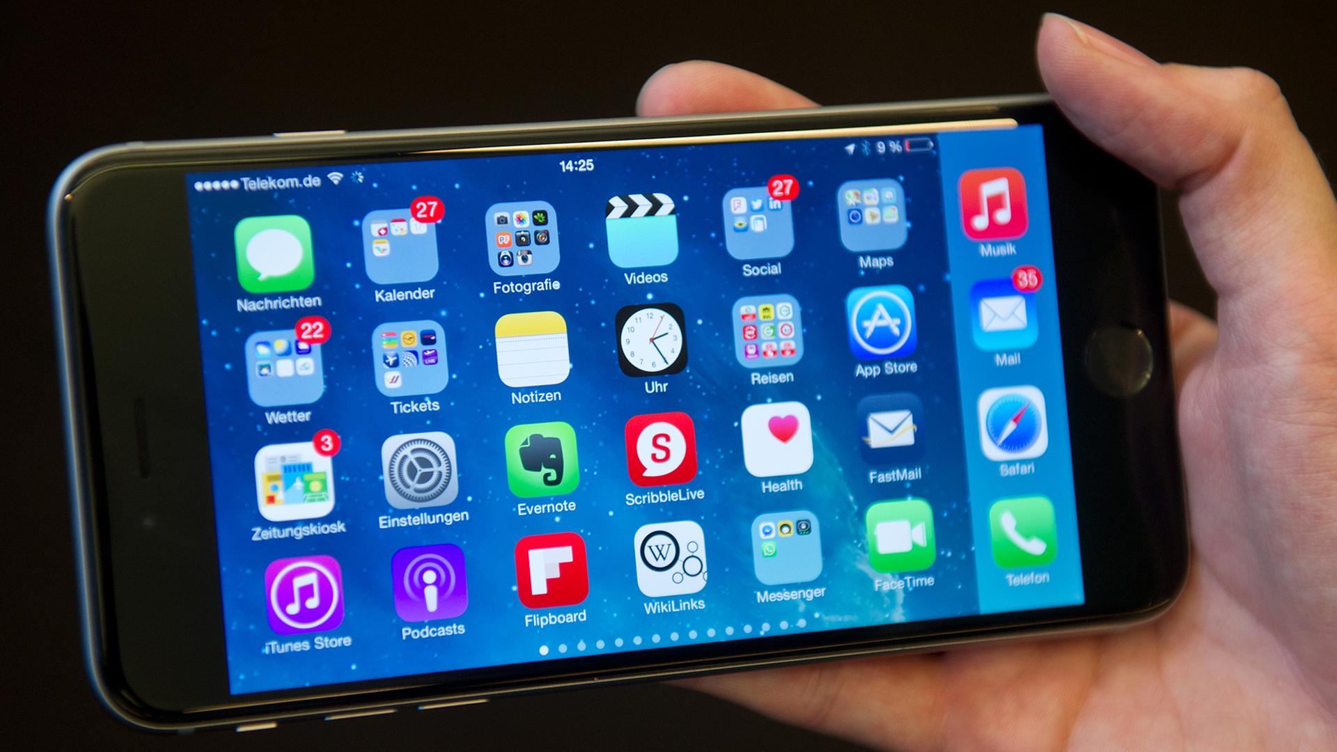 Eine Frau hält in Berlin ein iPhone 6 Plus mit verschiedenen Apps in ihrer Hand.