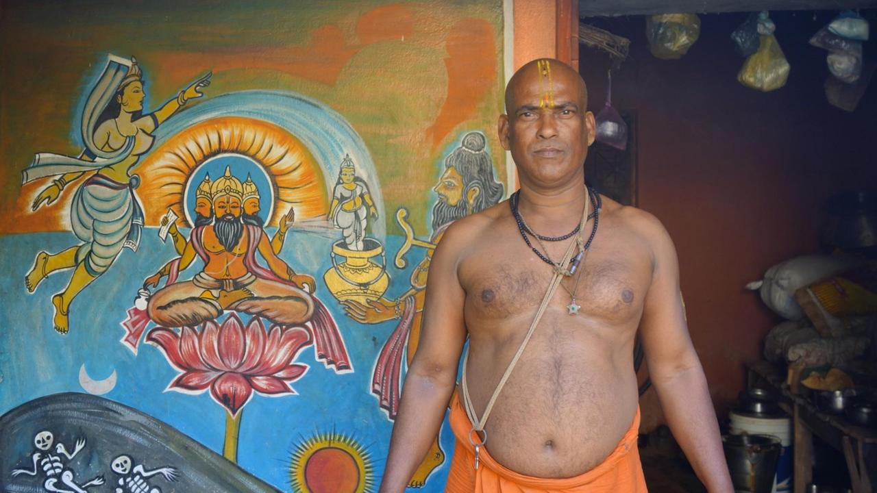 Im Hindu-Tempel von Amiyajhari behandelt der Priester und Heiler Manhanta Kailaaz auch psychisch Kranke mit getrockneten Pflanzen. Hier steht er oberkörperfrei vor einer Wand mit bunten Malereien.
