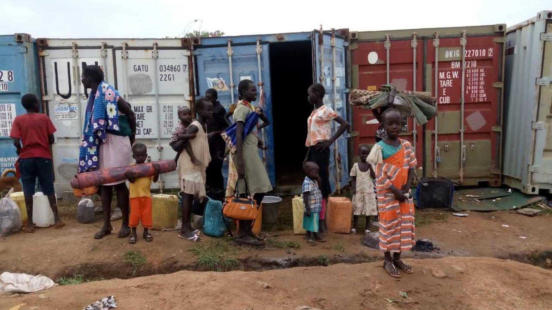 Menschen in der südsudanesischen Hauptstadt Juba stehen an Containern der UNO während der Waffenruhe.