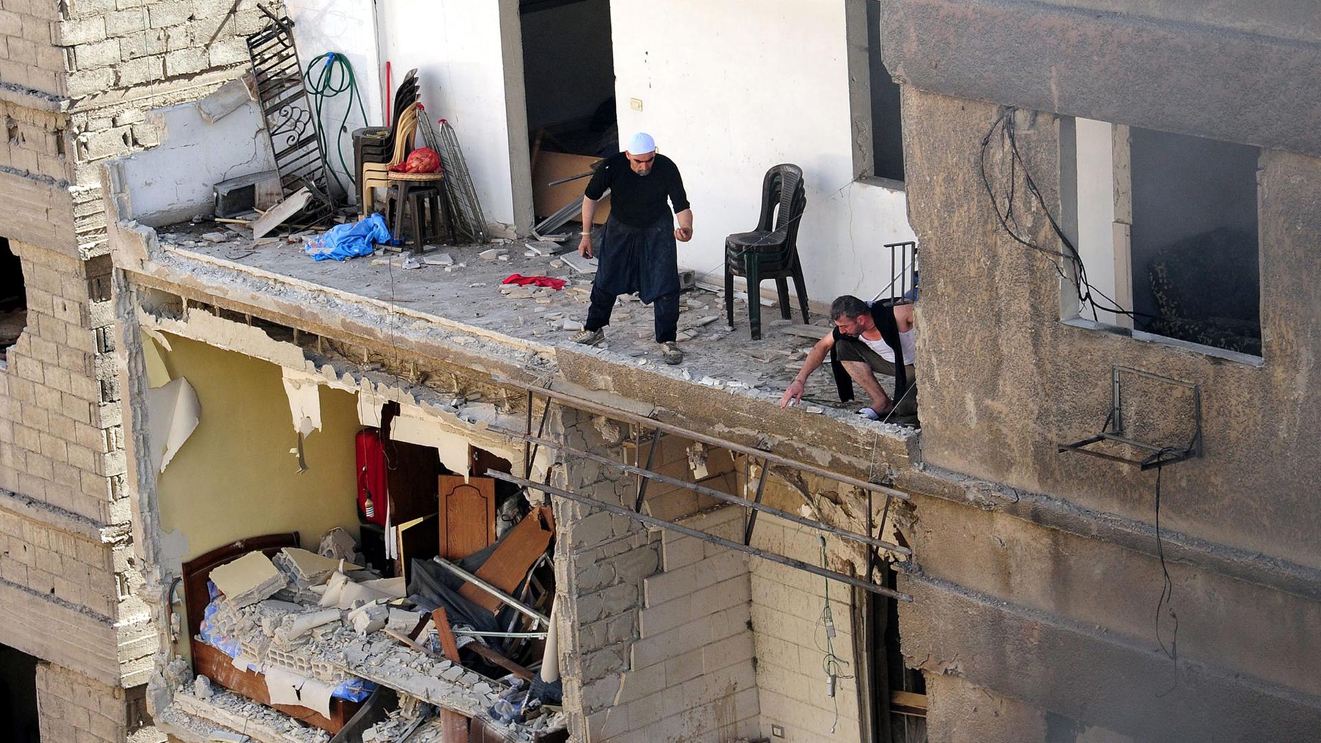 Menschen in einem zerstörten Gebäude nach einer Explosion in Damaskus Menschen in einem zerstörten Gebäude nach einer Explosion in Damaskus