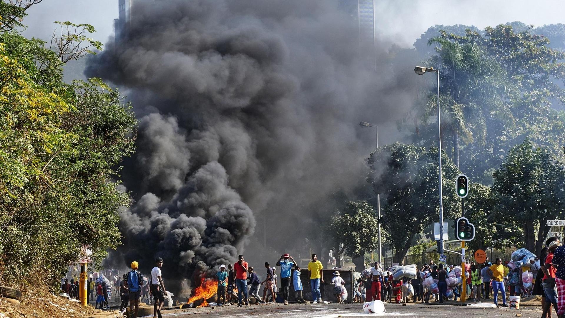Auf einer Straße in der Stadt Durban in Süd-Afrika brennt eine Barrikade.