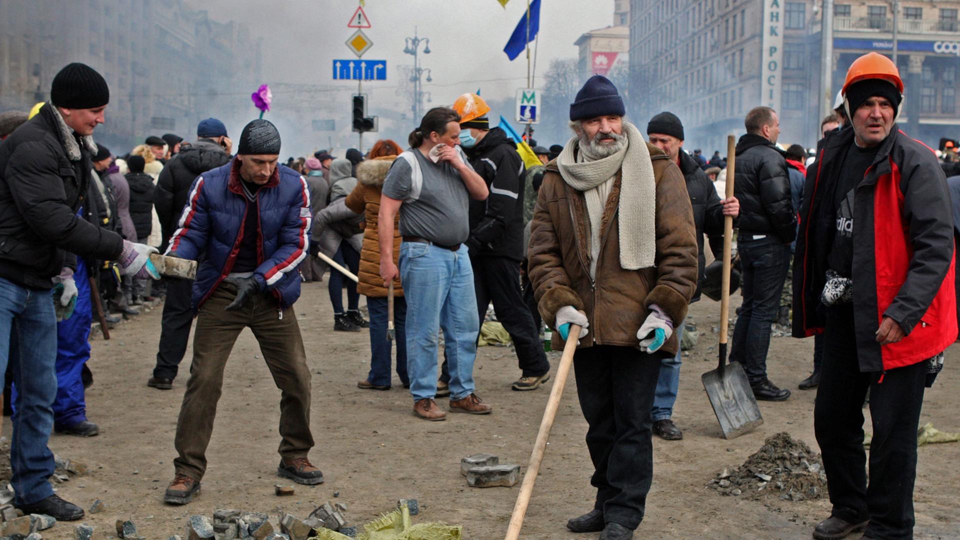 Protestierende im Zentrum von Kiew sammeln Pflastersteine.