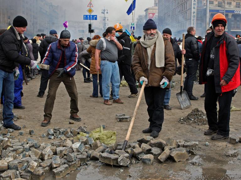 Protestierende im Zentrum von Kiew sammeln Pflastersteine.