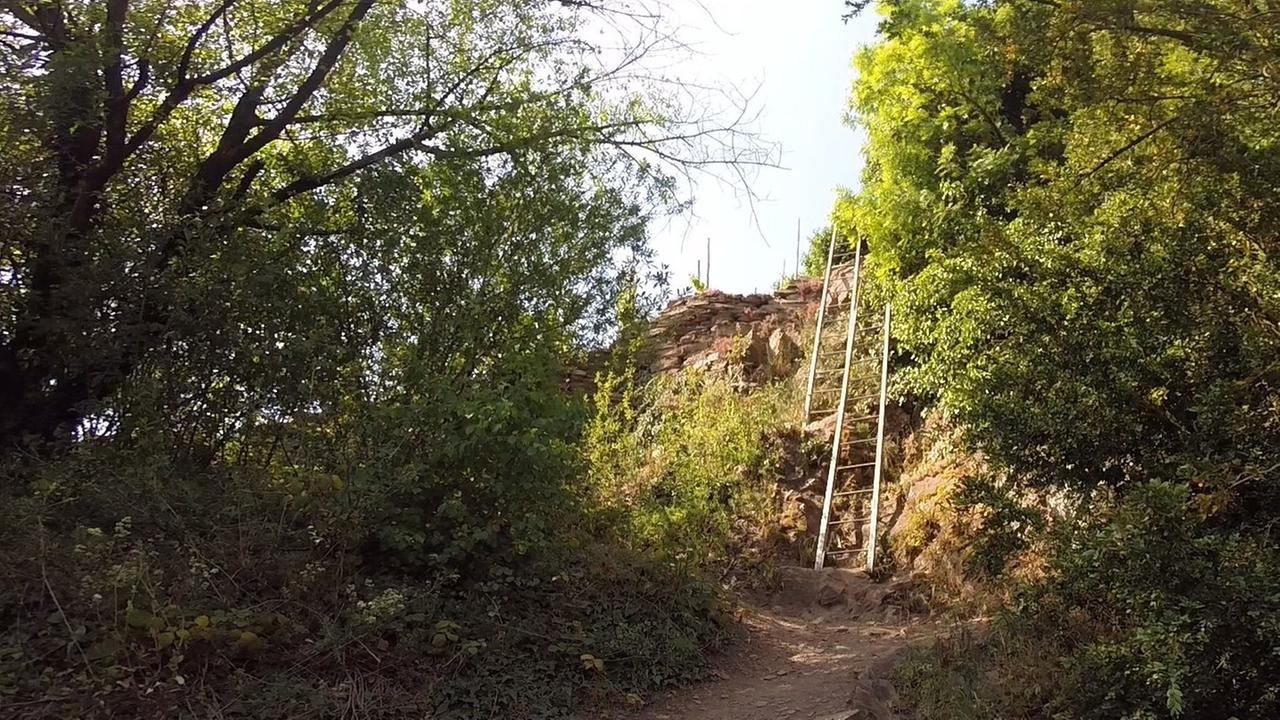 Eine Leiter steht an einem Steilfels.