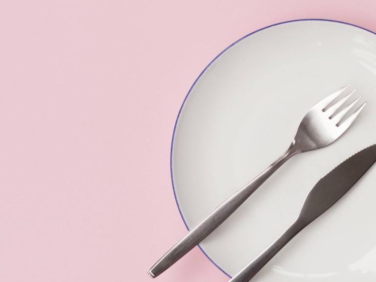 Ein leerer Teller mit Gabel und Messer.