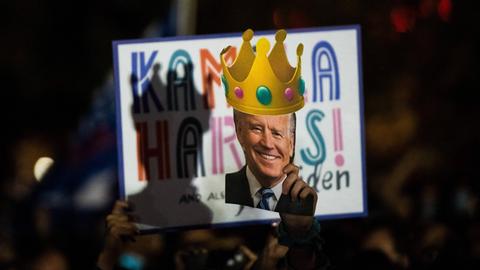 Biden-Anhänger verfolgen seine Rede nach seinem Wahlsieg auf einem Bildschirm.