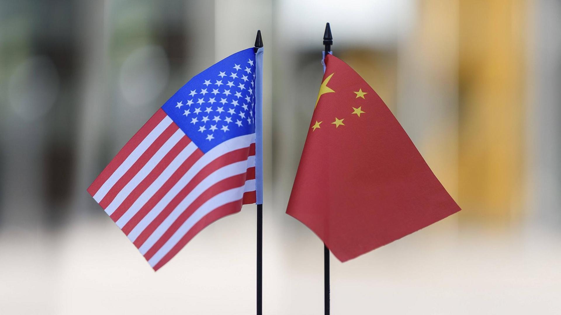 Eine amerikanische und eine chinesische Flagge stehen auf einem Tisch. Symbolfoto.