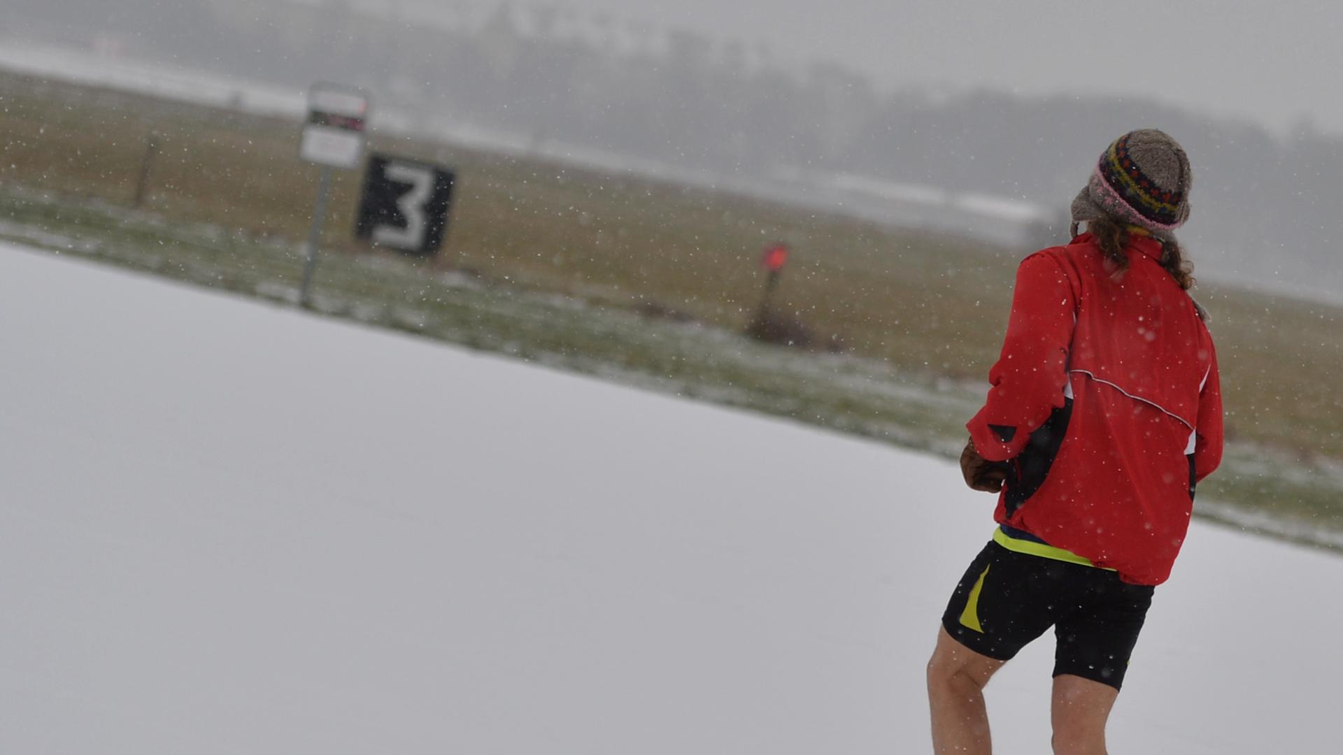 Ein Jogger läuft auf dem Tempelhofer Feld durch den Schnee