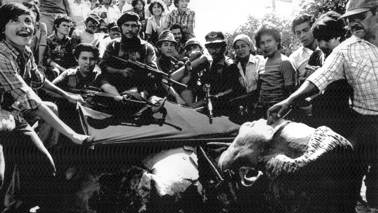 Sandinisten nach ihrem Sieg am 19. Juli 1979 in Managua neben einer umgestürzten Statue von Anastasio Somoza Garcia, dem Vater des besiegten Diktators Anastasio Somoza Debayle.
