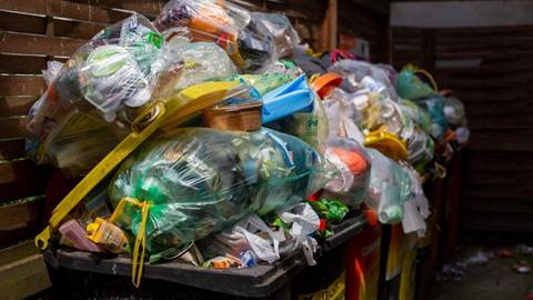 Überfüllte Müllcontainer stehen in einem Hinterhof. (zu dpa «30 Jahre Mülltrennung - Entsorger fordern bessere Plastikverpackungen» vom 09.06.2021)
