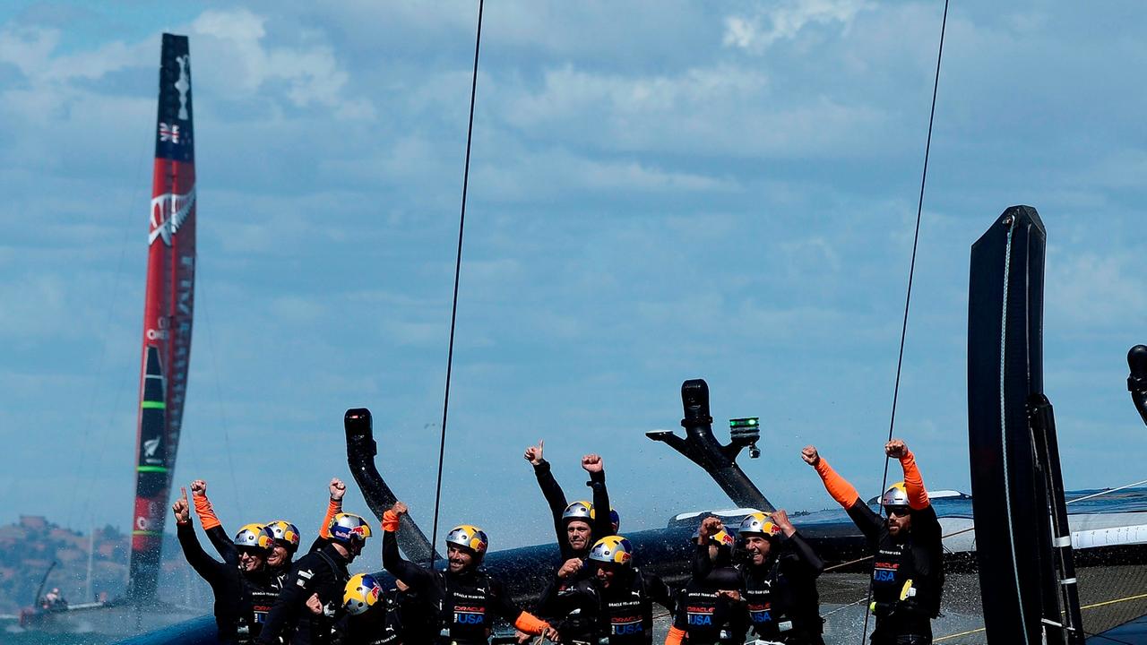 epa03884238 James 'Jimmy' Spithill of Australia (Second-L), helmsman and skipper of Oracle Team USA and crew celebrate after crossing the finish line ahead Emirates Team New Zealand (L) in a winner-takes-all Race 19 during the America's Cup Finals on the 
