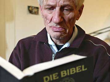 Ein alter Mann liest in der Bibel