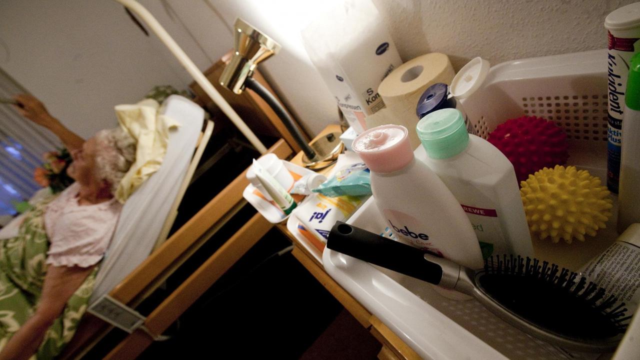 Eine pflegebedürftige Frau liegt zu Hause in ihrem Bett.