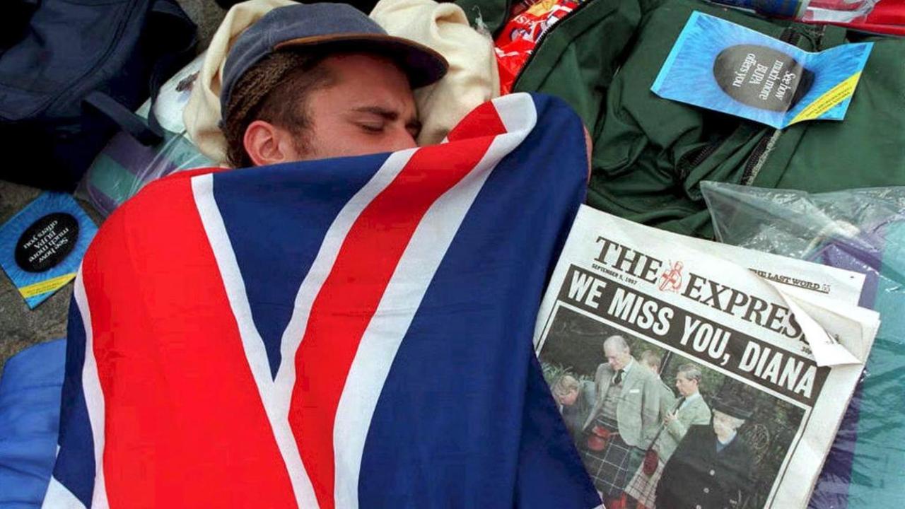 Eingehüllt in die britische Fahne schläft ein Trauernder vor der Westminster-Abtei in London. Bereits einen Tag vor der Trauerfeier für Prinzessin Diana kampierten in London rund 250 Menschen vor der Westminster-Abtei. Sie wollten sich einen günstigen Platz für die Feierlichkeiten sichern. 