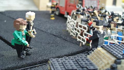 Angela Merkel als Lego-Figur vor Pressefotografen