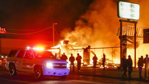 Polizeiauto vor einem brennenden Geschäftshaus in Ferguson (US-Bundesstaat Missouri) in der Nacht zum 25. November