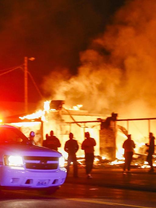 Polizeiauto vor einem brennenden Geschäftshaus in Ferguson (US-Bundesstaat Missouri) in der Nacht zum 25. November