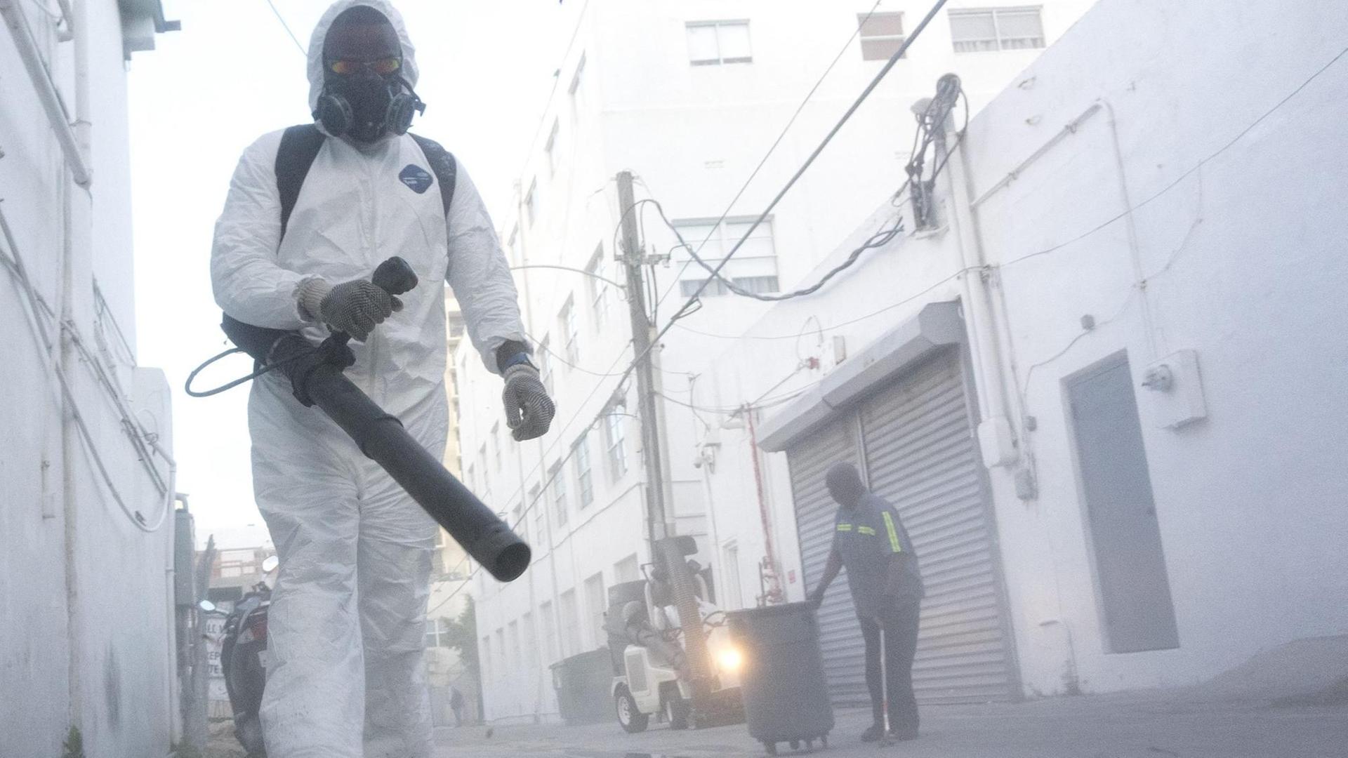 Arbeiter mit Schutzanzügen in Miami Beach reinigen die Straßen