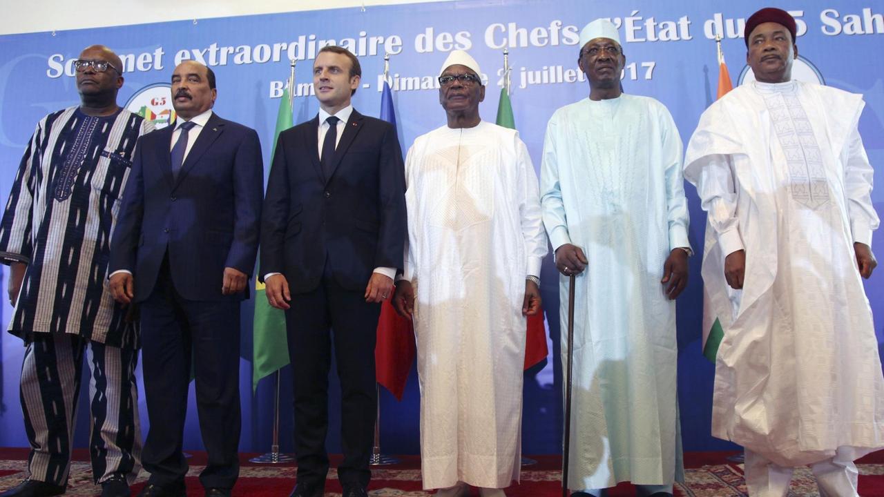 Das Bild zeigt den französischen Präsidenten Macron als Gast des G5-Sahel-Gipfels in der Mitte zwischen den Staatschefs von Burkina Fasos, Roch Marc Christian Kabore, Mauritanien, Mohamed Ould Abdel Aziz, Mali, Ibrahim Boubacar Keita, Tschad, Idriss Deby und Niger, Mahamadou Issoufou (von links). Sie stehen auf einem roten Teppich vor einer blauen Wand.