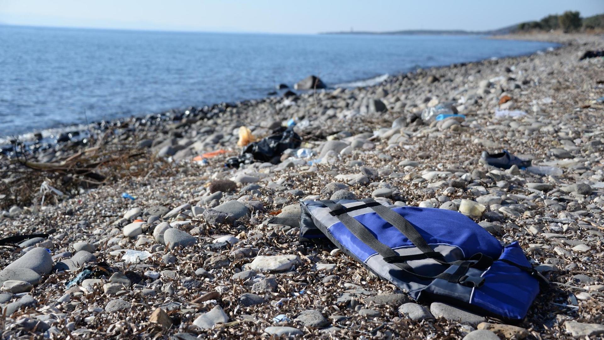 Eine blaue Schwimm-Weste liegt an einem Strand an der türkischen Küste. Eine blaue Schwimm-Weste liegt an einem Strand an der türkischen Küste.