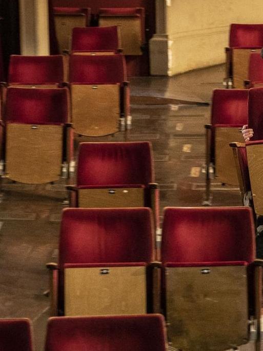 Ein Mann entfernt Stühle aus dem Zuschauerraum eines Theaters