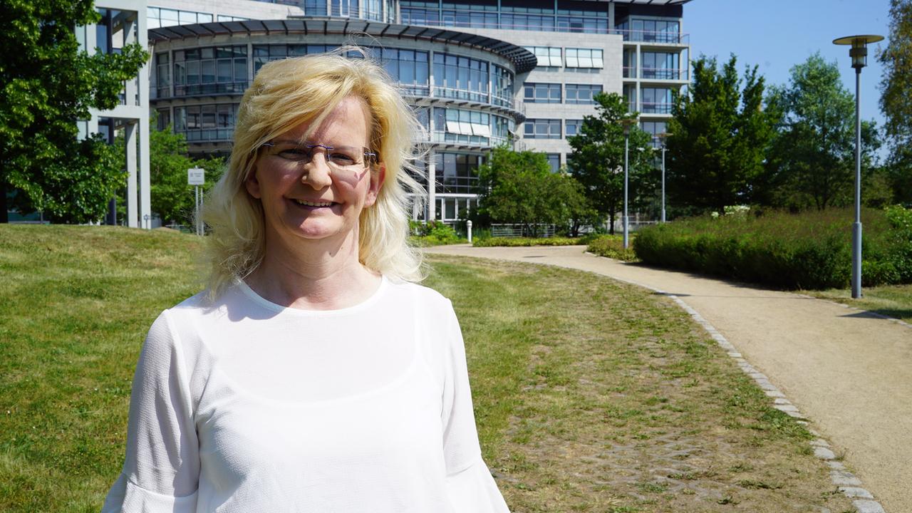 Simone Pareigis steht vor einem Gebäude.