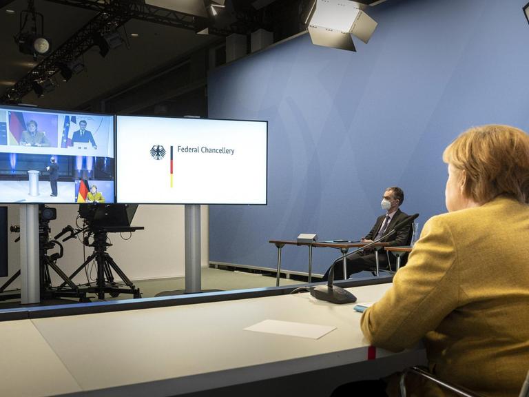 Bundeskanzlerin Angela Merkel (CDU) während einer Videokonferenz im Bundeskanzleramt im Rahmen der Münchner Sicherheitskonferenz mit US-Präsident Joe Biden und dem französischen Präsidenten Emmanuel Macron (auf dem Bildschirm)
