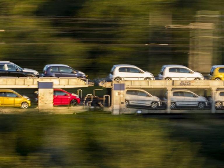 Ein fahrender Güterzug hat Autos der Marke VW geladen