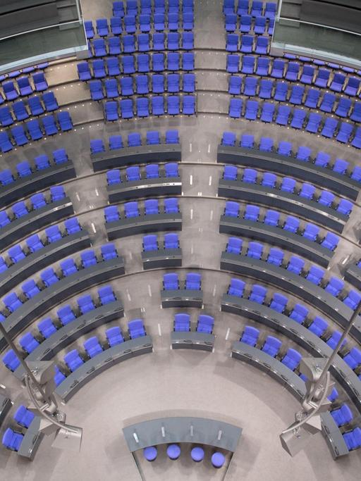 Eine Gruppe Besucher sitzt im Plenarsaal im Reichstag in Berlin.