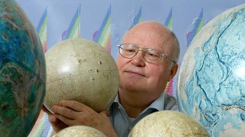 Professor Gerhard Neukum, Professor für Planetologie an der Freien Universität Berlin (gest. 2014), Eingerahmt von Modellen der Planeten Venus (l), des Erdmonds, Merkur und Erde