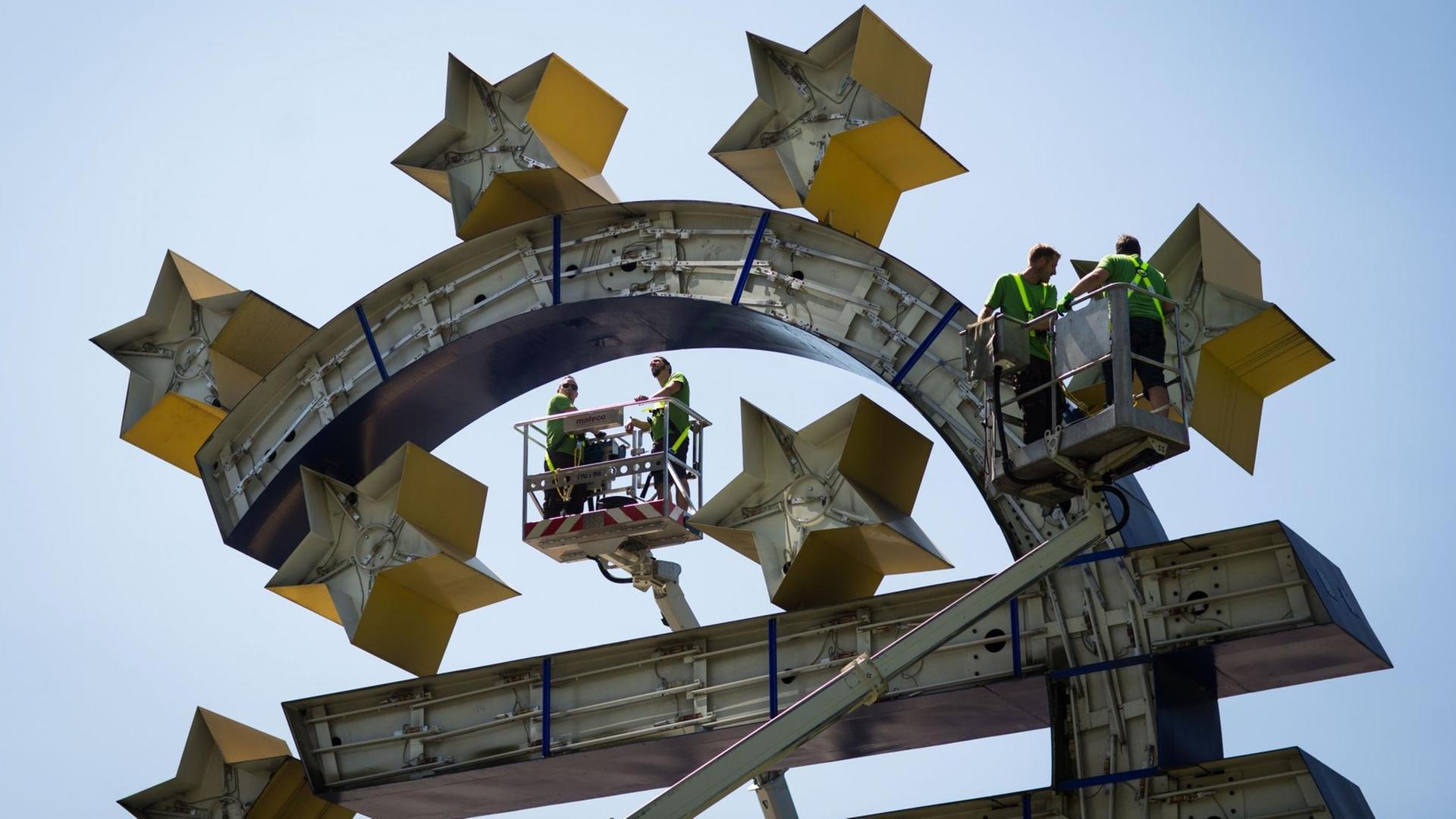 Arbeiter demontieren in Frankfurt am Main die Beleuchtung der Euro-Skulptur vor der ehemaligen Zentrale der Europäischen Zentralbank (EZB). Das Kunstwerk von Ottmar Hörl wird nach 13 Jahren erstmals grundsaniert. Arbeiter demontieren in Frankfurt am Main die Beleuchtung der Euro-Skulptur vor der ehemaligen Zentrale der Europäischen Zentralbank (EZB). Das Kunstwerk von Ottmar Hörl wird nach 13 Jahren erstmals grundsaniert.