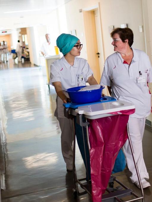 Krankenpflegeschülerin Türkan Deniz und Krankenschwester Marianne Weber laufen durch einen Flur im Vivantes-Humboldt-Klinikum in Berlin.